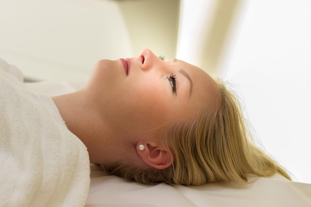 Client lying back on a treatment bed, calm and looking up